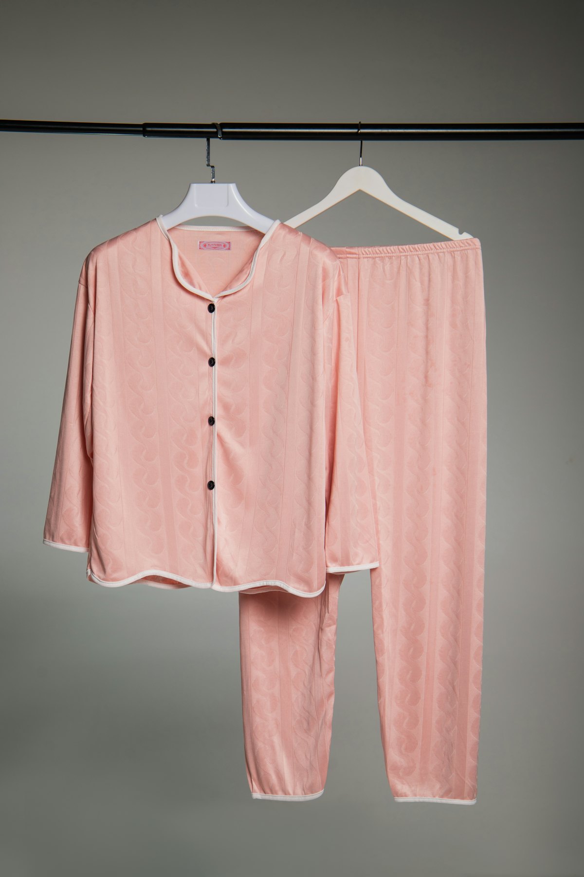 Pijama rosa colgado en una percha